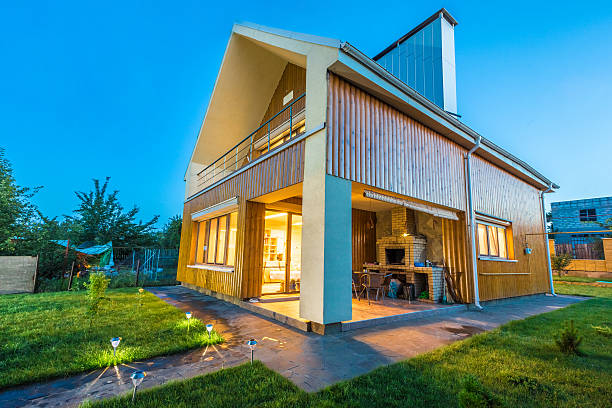 Beautiful wooden house with a lawn. Facade of traditional homes with grass in the foreground. at sunset and sunrise